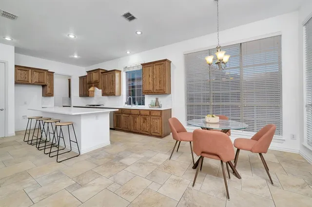 a kitchen with stainless steel appliances kitchen island granite countertop a sink and a refrigerator
