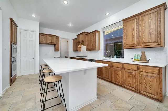a kitchen with stainless steel appliances kitchen island granite countertop a sink and cabinets