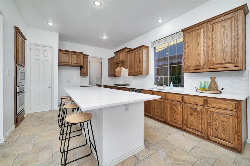 9328 Old Veranda Road Plano, TX 75024 - Photo 13 of 40 a kitchen with stainless steel appliances kitchen island granite countertop a sink and cabinets