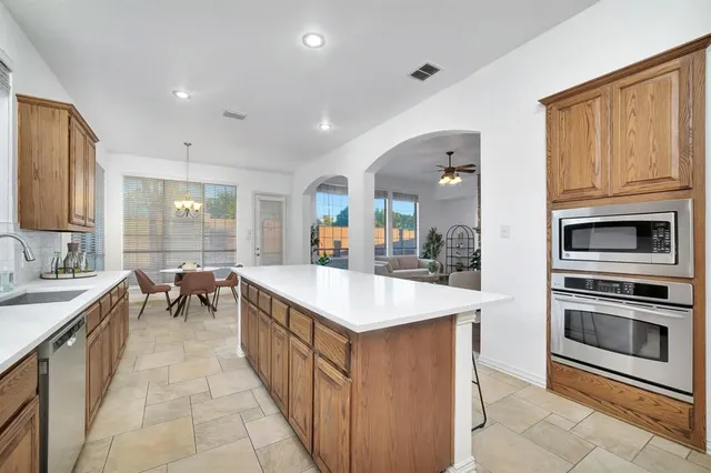 a kitchen with stainless steel appliances kitchen island granite countertop a sink and cabinets
