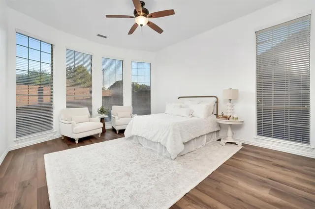 a spacious bedroom with a bed and glass door