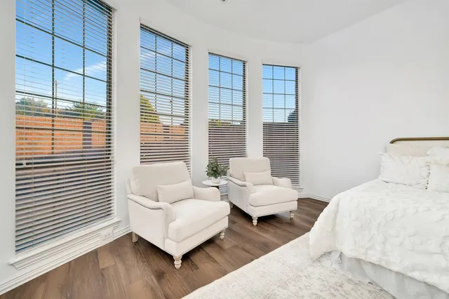 a bedroom with furniture and a large window