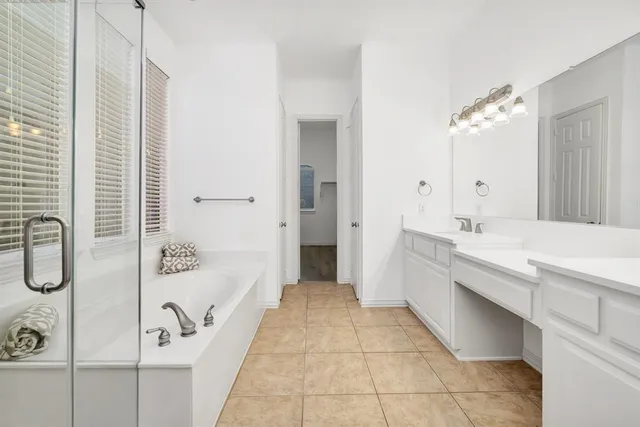 a bathroom with a tub sink and mirror