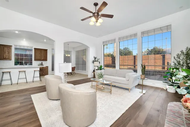 a living room with furniture and a large window with wooden floor