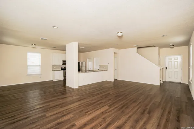 a view of empty room with wooden floor