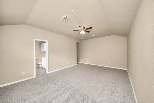 a view of an empty room with a chandelier fan