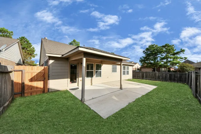 a view of a house with a yard and fence