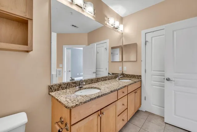 a bathroom with a granite countertop sink and a mirror