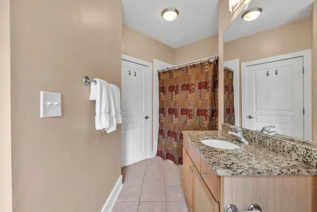 a bathroom with a granite countertop sink a mirror and a shower