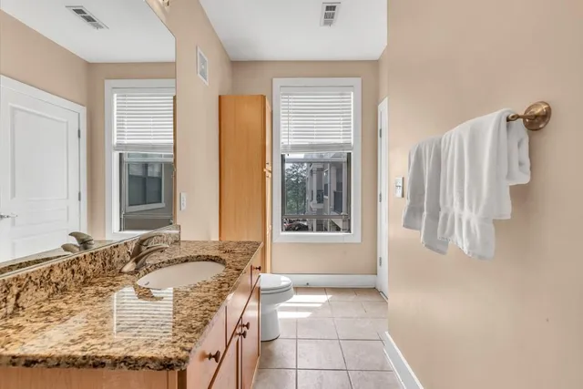 a bathroom with a granite countertop sink and a mirror
