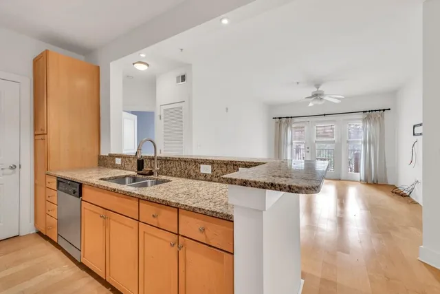 a kitchen with stainless steel appliances granite countertop a sink and cabinets with wooden floor