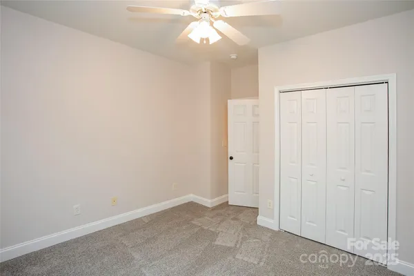 an empty room with a ceiling fan and a window