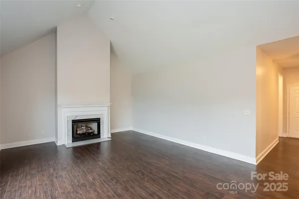 a view of a livingroom with wooden floor and a fireplace