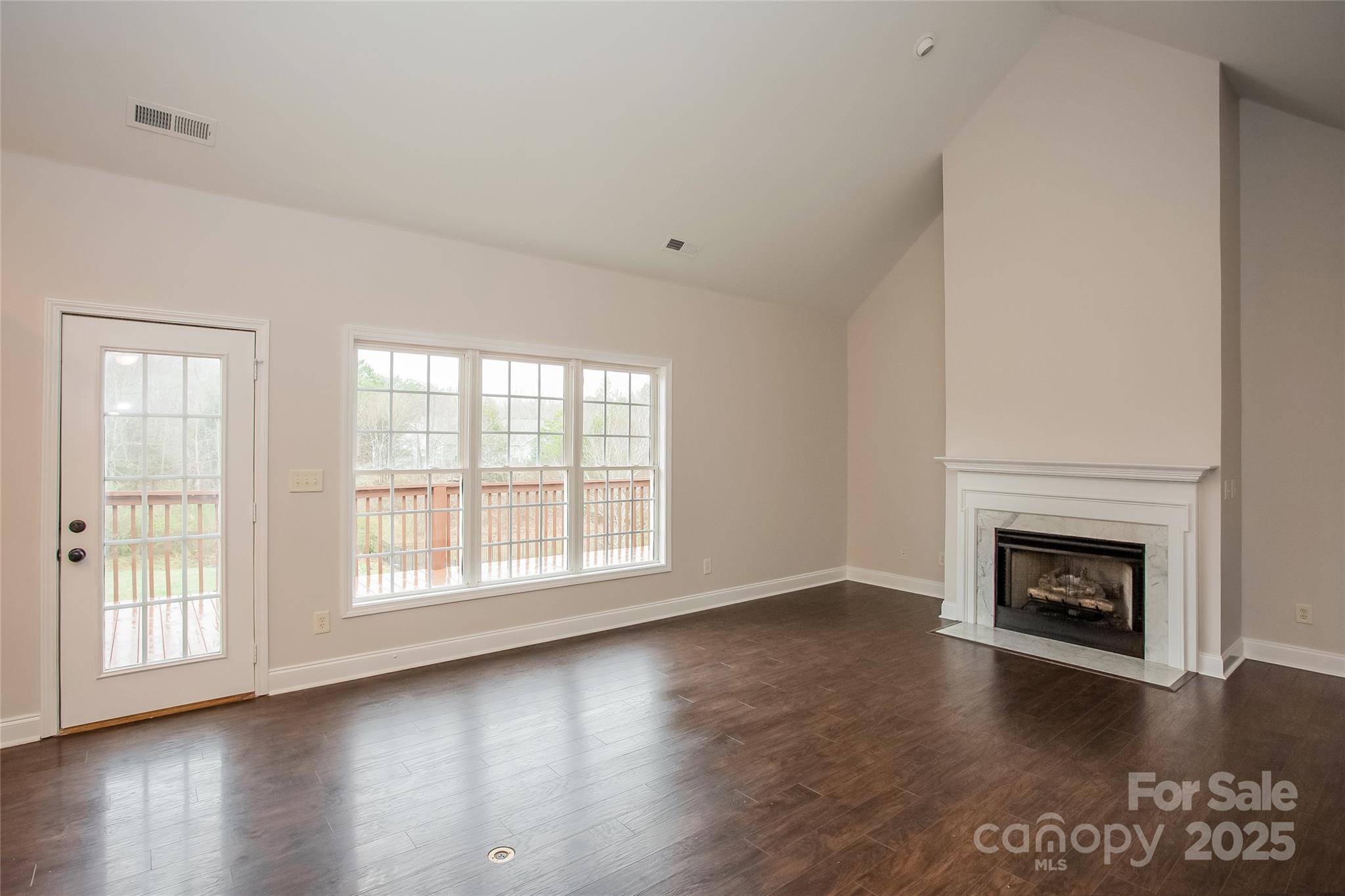841 Old Farm Road Oakboro, NC 28129 - Photo 5 of 20 an empty room with wooden floor fireplace and windows