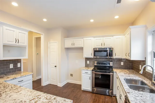 a kitchen with stainless steel appliances granite countertop a stove and a refrigerator