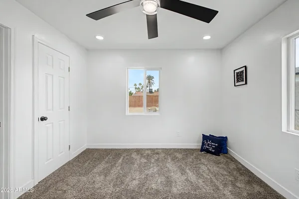 an empty room with a ceiling fan and window