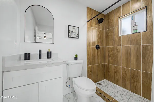 a bathroom with a sink a toilet and shower