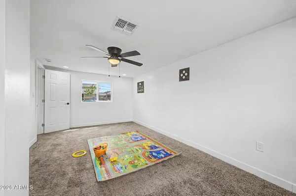an empty room with windows and ceiling fan