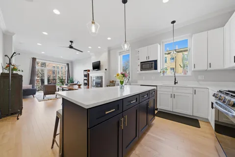 a kitchen with kitchen island granite countertop a sink appliances and cabinets