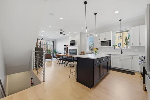a kitchen with stainless steel appliances kitchen island granite countertop a sink counter and chairs