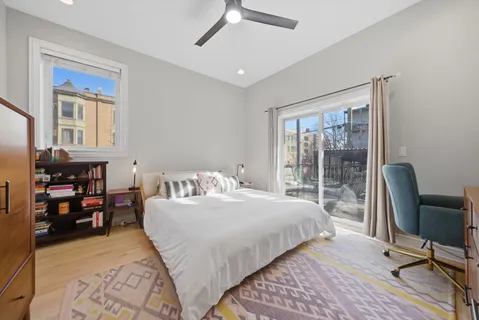 a bedroom with a bed wooden floor and a window