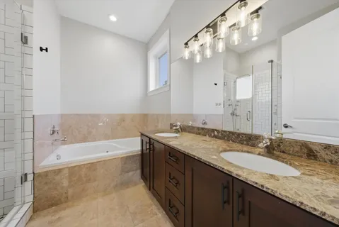 a bathroom with a granite countertop double vanity sink and a mirror