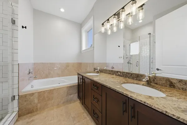 a bathroom with a granite countertop double vanity sink and a mirror
