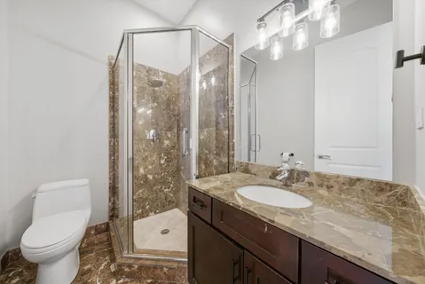 a bathroom with a granite countertop sink toilet and shower