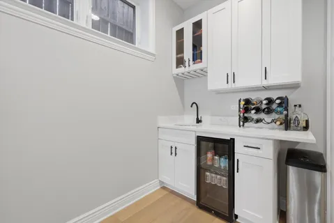 a kitchen with white cabinets and sink