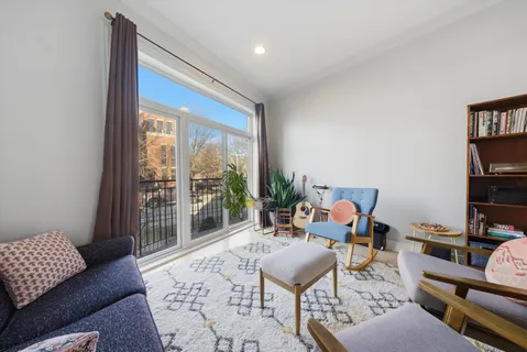 a living room with furniture and a floor to ceiling window