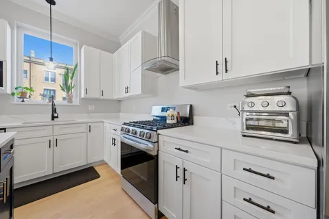 a kitchen with cabinets appliances a sink and a counter top space