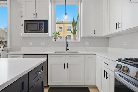 a kitchen with white cabinets and white appliances