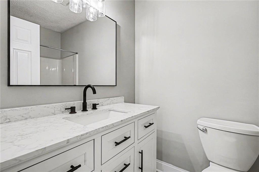 6052 WinterGreen Road Northwest Norcross, GA 30093 - Photo 18 of 24 a bathroom with a sink a toilet and mirror