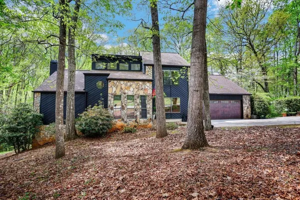 a view of a house with backyard and trees