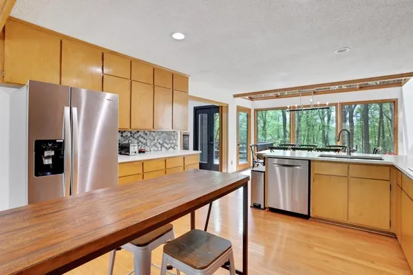 a kitchen with stainless steel appliances granite countertop a refrigerator and wooden cabinets
