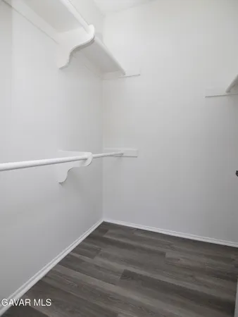 a view of an empty room with wooden floor and closet