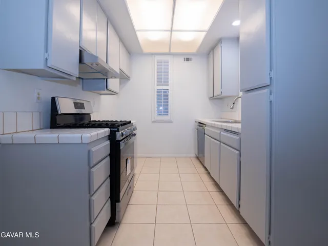 a kitchen with stainless steel appliances a sink stove and cabinets