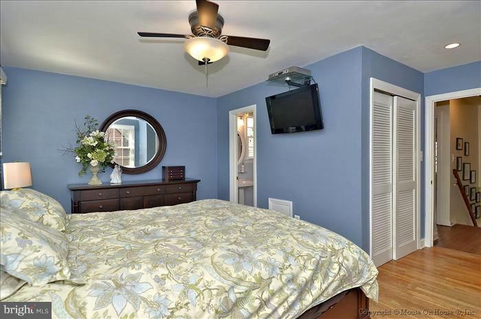 5512 Northfield Road Bethesda, MD 20817 - Photo 3 of 29 a bedroom with a bed a mirror on dresser and a chandelier