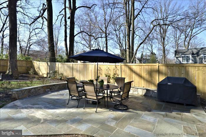 5512 Northfield Road Bethesda, MD 20817 - Photo 26 of 29 a view of a patio with table and chairs under an umbrella with large trees