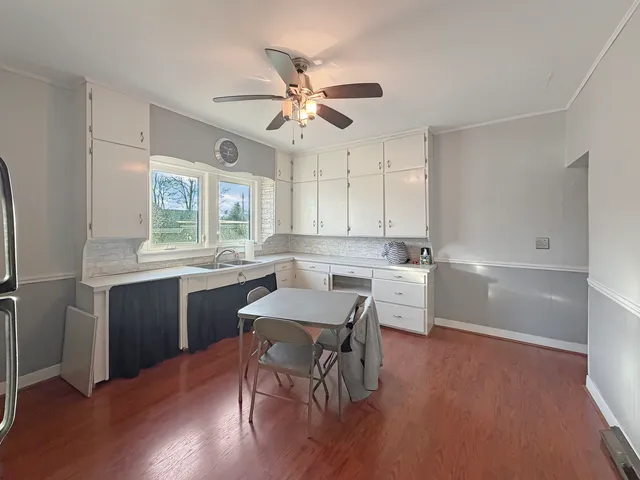 a kitchen with a table chairs a sink dishwasher window and cabinets