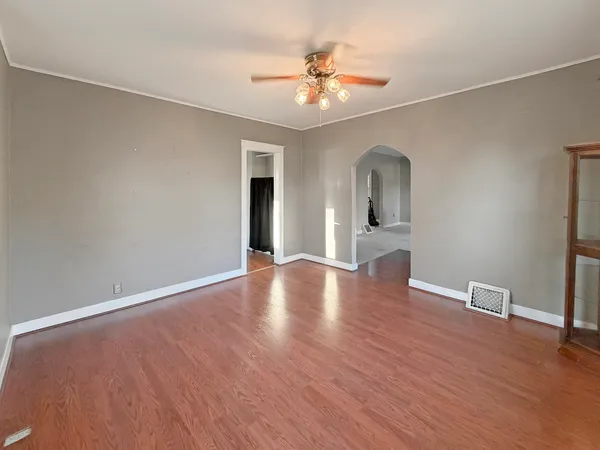 a view of an empty room with wooden floor