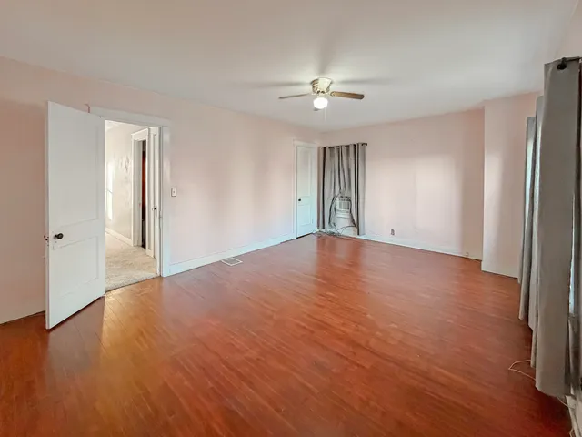 a view of an empty room with wooden floor