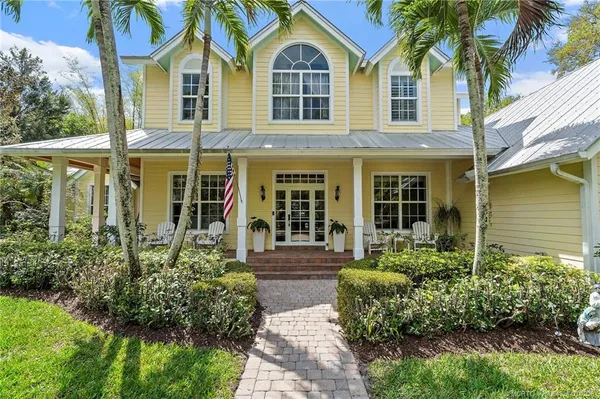 a front view of a house with yard and green space