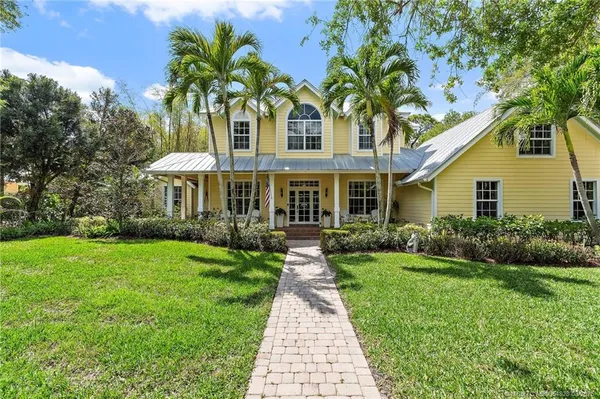 a front view of a house with a yard and shrubs