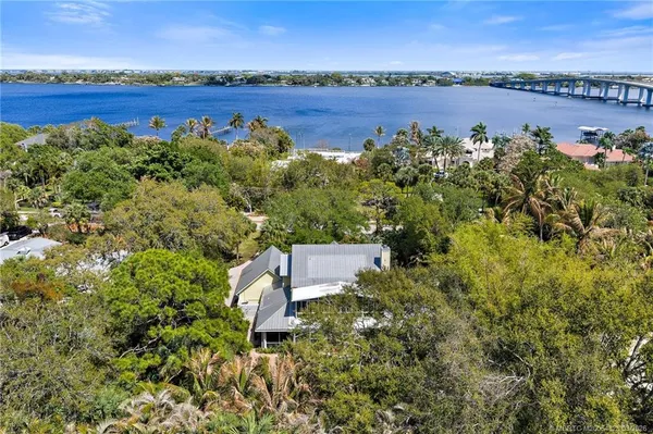 a view of backyard with seating space and trees in the background