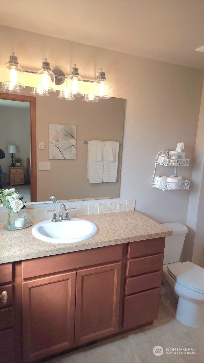19312 Patterson Road East Orting, WA 98360 - Photo 22 of 39 a bathroom with a granite countertop sink a toilet and mirror