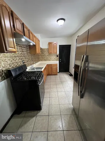 a kitchen with stainless steel appliances granite countertop a refrigerator and a stove