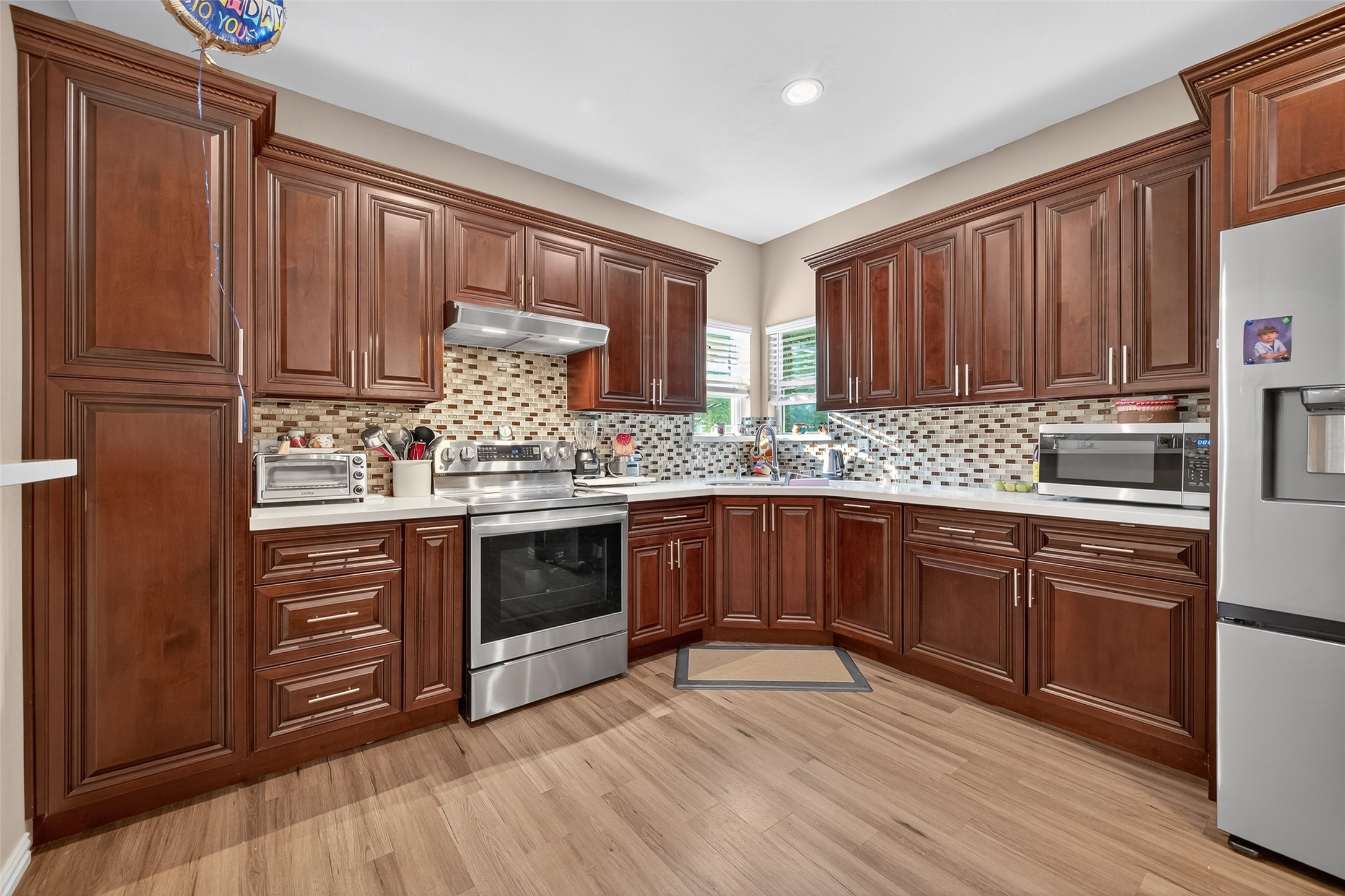 1619 Dolores Street Rosharon, TX 77583 - Photo 13 of 31 a kitchen with stainless steel appliances granite countertop wooden cabinets a sink and dishwasher a stove with wooden floor