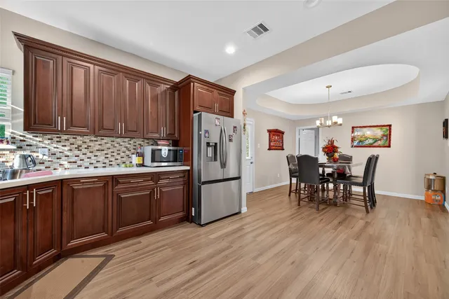 a kitchen with refrigerator cabinets dining table and chairs