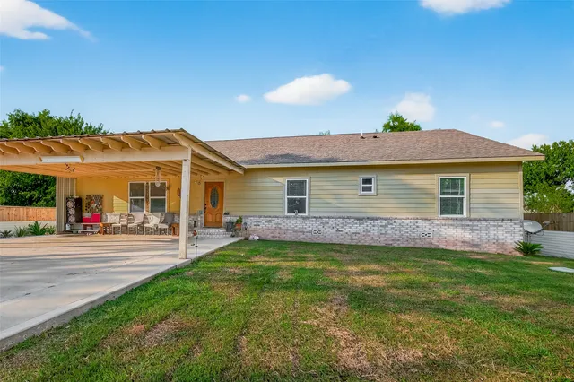 a view of a house with a yard and sitting area